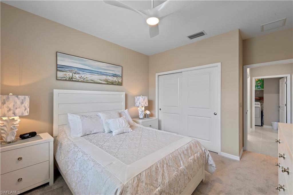 Bedroom featuring neutral wall colors, carpet flooring, a ceiling fan with integrated lighting, and a closet with sliding panel doors
