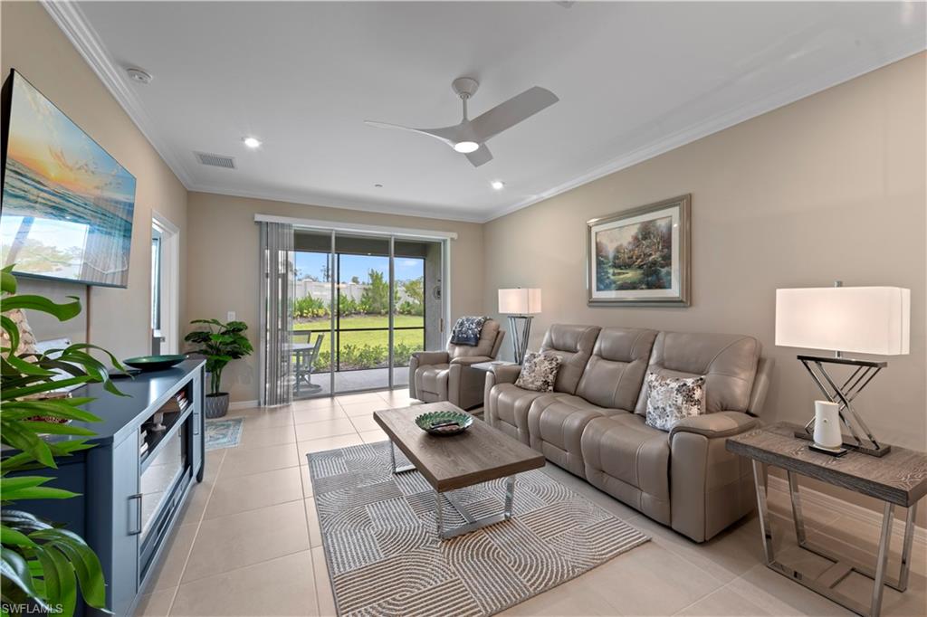Great Room floor plan for easy living. Featuring tile flooring, crown molding, and sliding doors leading to the enclosed lanai area.