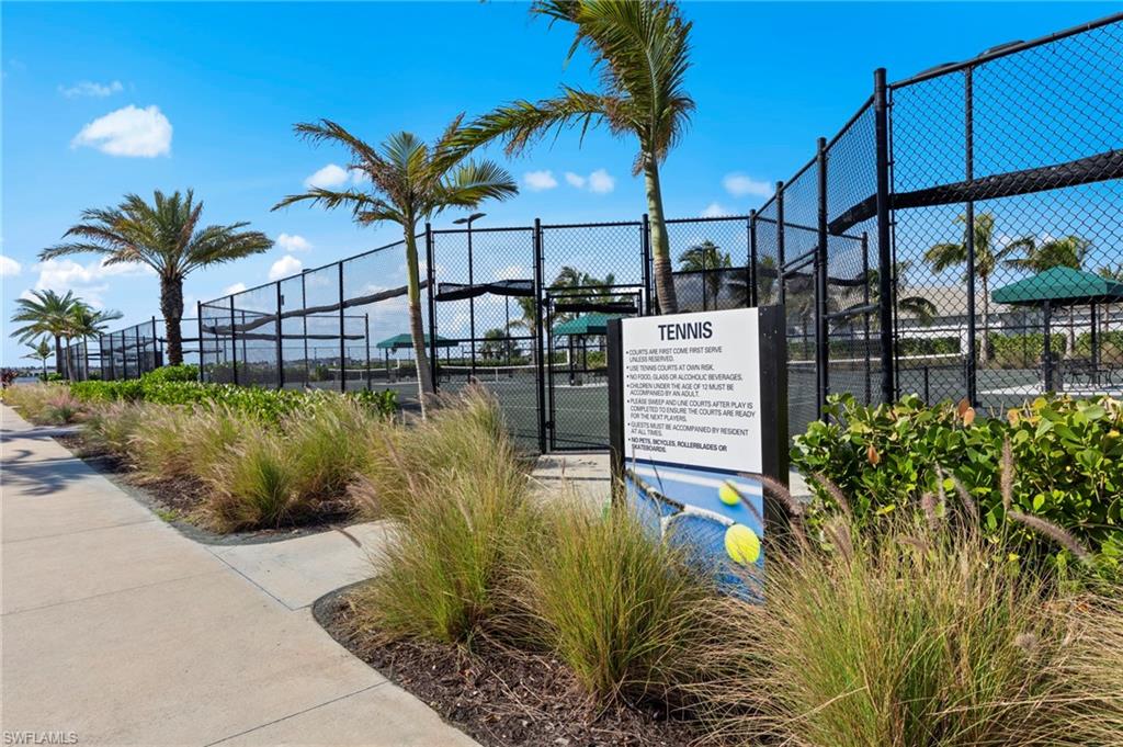 Community tennis courts featuring black chain-link fencing and multiple courts