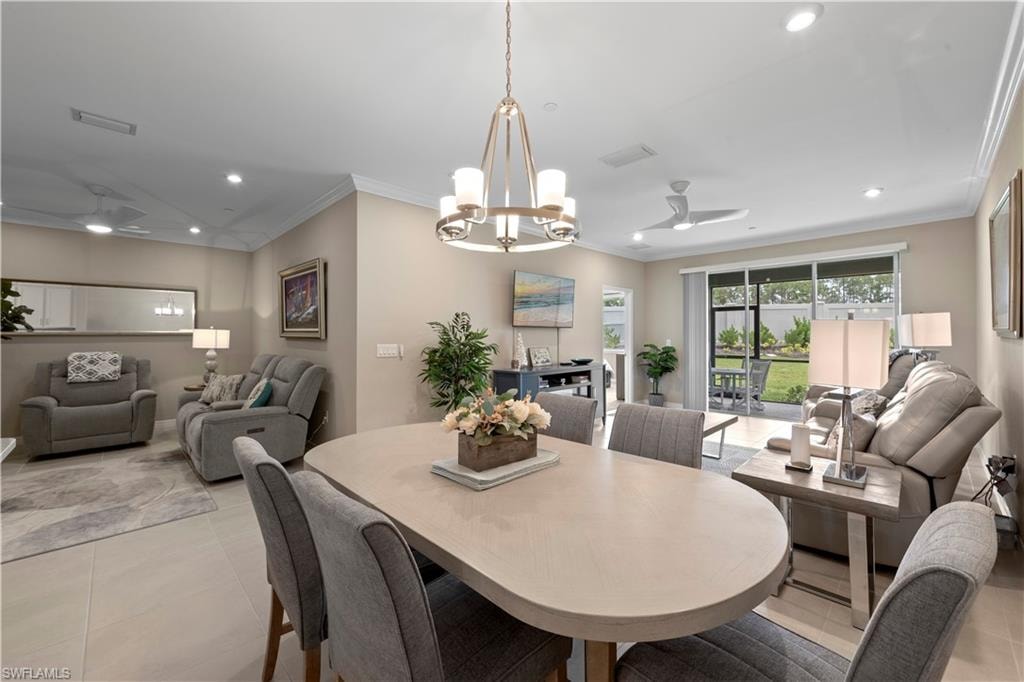 Dining space with a contemporary chandelier, recessed lighting, and crown molding.