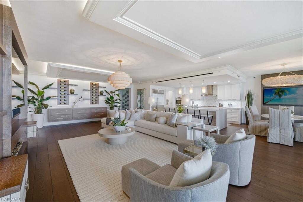 Expansive living space featuring dark wood-finish flooring and a light-toned area rug