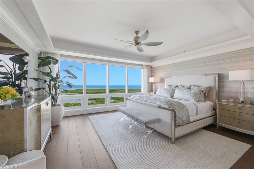 Floor-to-ceiling windows overlooking a water and landscape backdrop