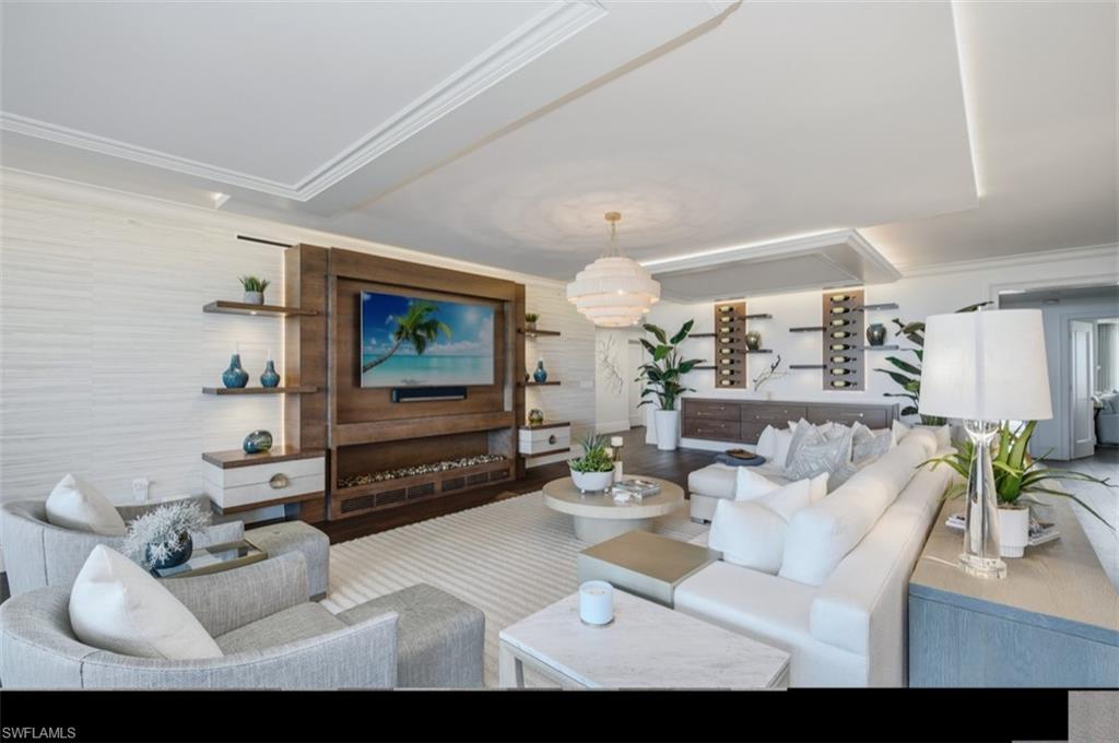 Spacious living area featuring a wood-panel media wall with integrated shelving and ambient lighting