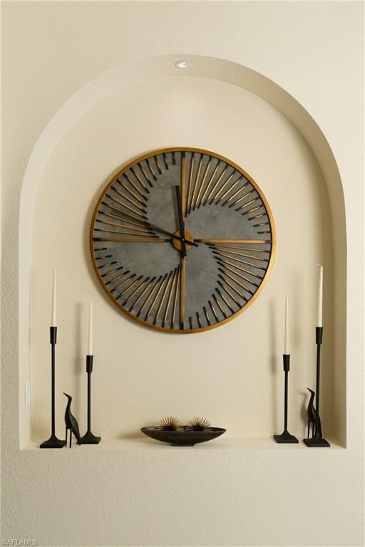 Recessed arched niche featuring a built-in shelf and overhead lighting