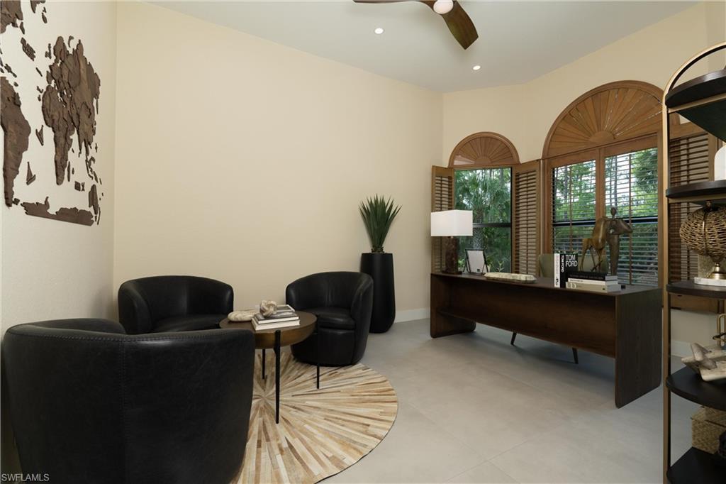 Expansive room featuring light-colored walls and large arched windows with wooden shutters