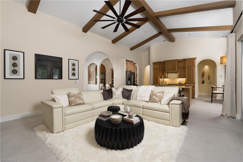 Vaulted ceilings with exposed wood beams, a prominent ceiling fan, and recessed lighting