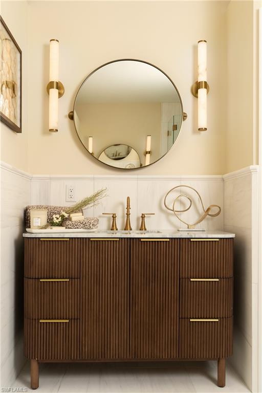 Fluted wood-finish vanity with a white countertop and brass hardware
