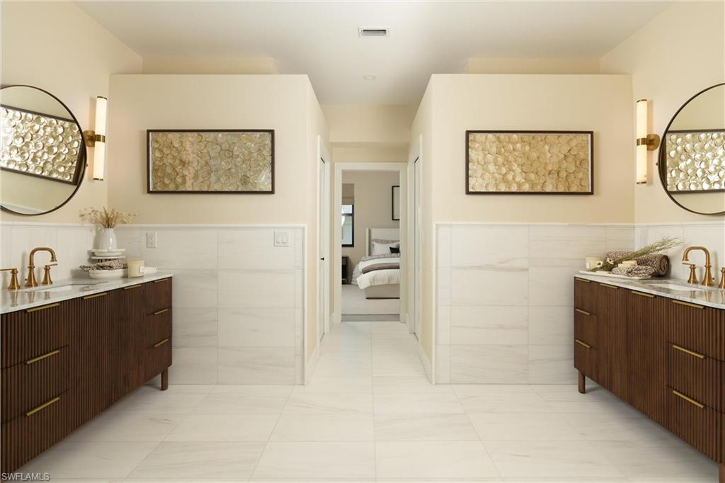 Dual wood-finish vanities with gold-tone hardware, undermount sinks, and wall-mounted gold-tone faucets