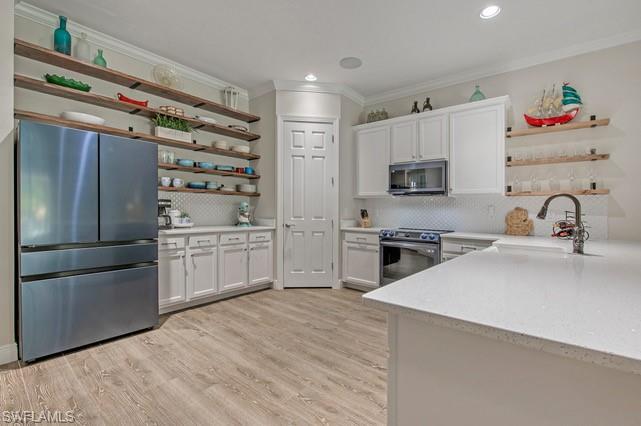 Contemporary kitchen featuring light wood-finish flooring and white perimeter cabinetry
