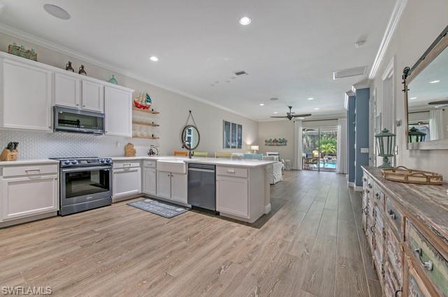 Spacious kitchen featuring white cabinetry, an apron front sink, and a stainless steel appliance suite
