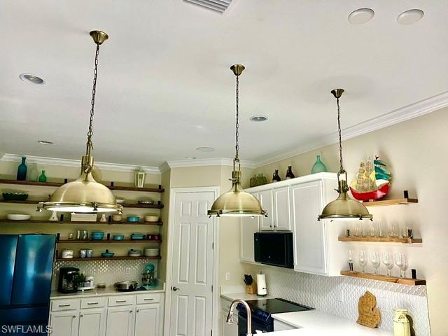 Kitchen featuring three brass pendant lights, recessed ceiling lighting, crown molding, white cabinetry, and open wood shelving