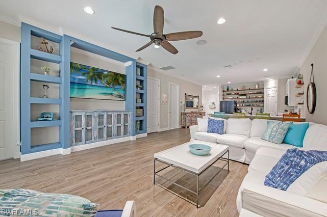 Open-concept living space with wood-finish flooring, recessed lighting, and a ceiling fan