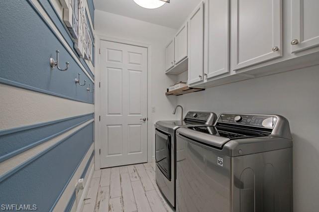 Dedicated utility space featuring overhead white cabinetry, a utility sink with a high-arch faucet, and distressed wood-finish flooring