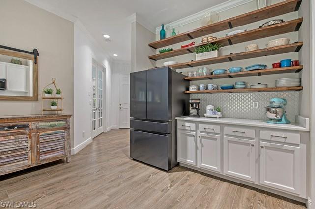 Built-in cabinetry with white shaker-style doors, quartz countertop, and a textured backsplash