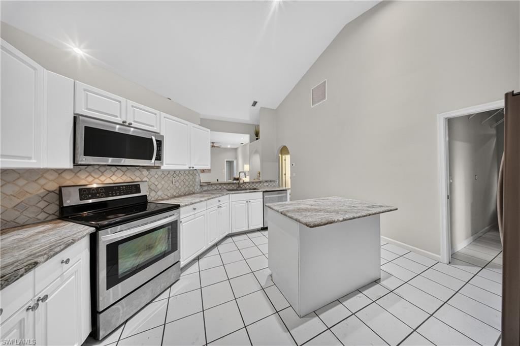 Stainless range and microwave, granite counters and generous cabinet storage.