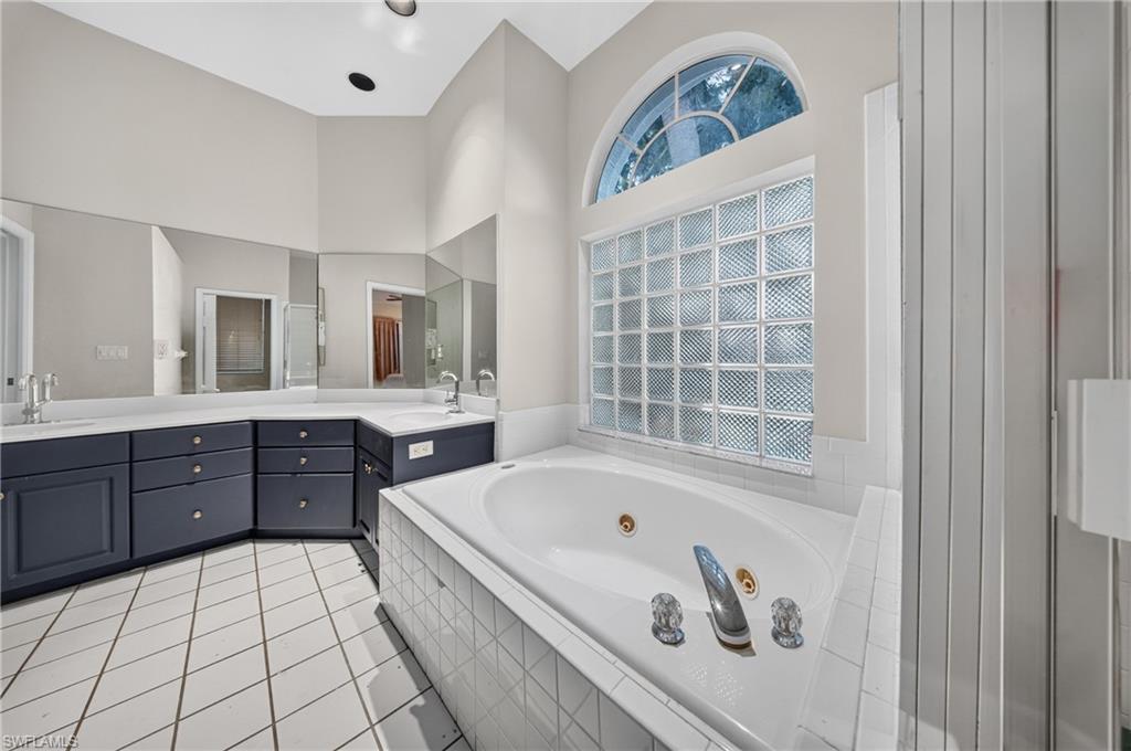 Soak and unwind — garden tub beneath an arched window in the renovated primary bath.
