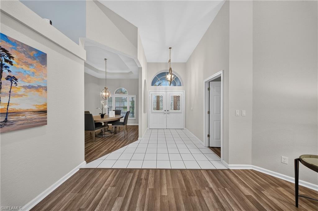 Grand double-door entry with arched transom and volume ceilings sets a bright, airy tone.
