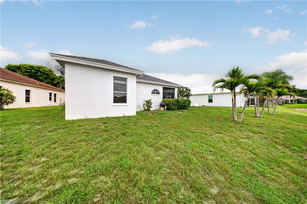 Mature royal palms and open green space frame the private backyard.