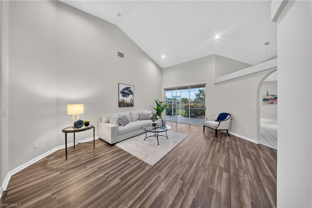 Formal living room with a wall of sliders to the backyard and pond, filled with afternoon light.