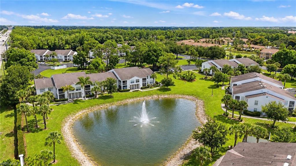 Lush landscaping surrounds a reflective pond with a central fountain feature