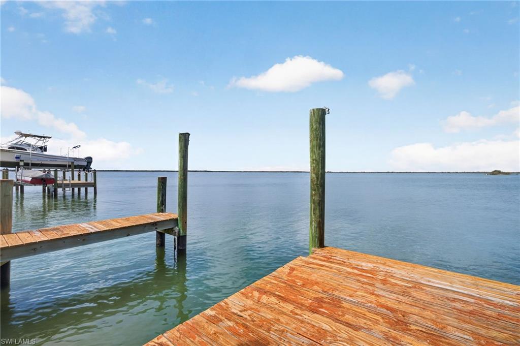 Private dock featuring wood-plank decking and robust pilings