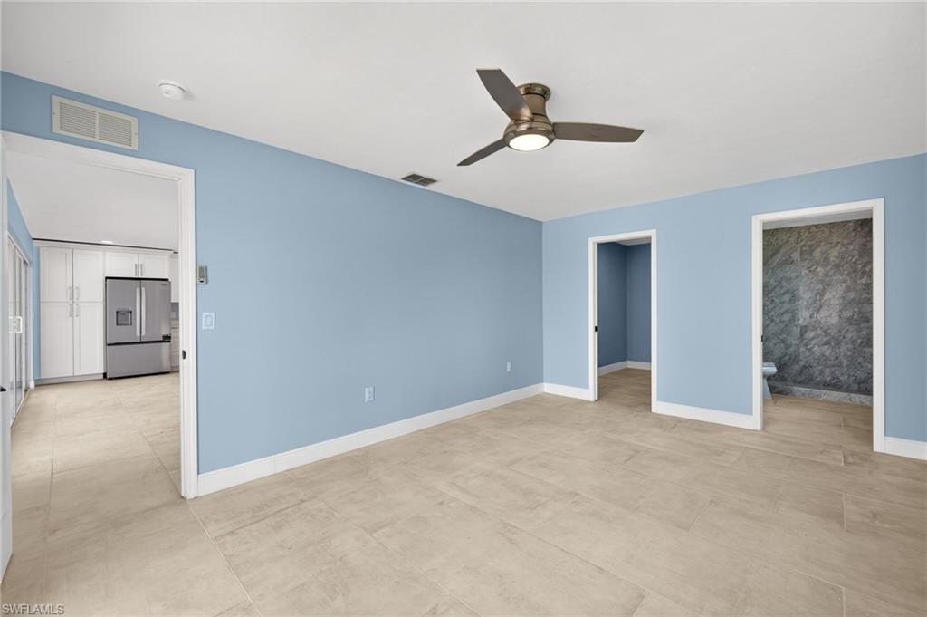 Spacious room with light blue walls and neutral tile flooring
