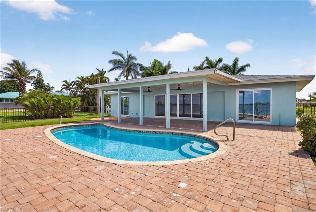 Exterior featuring a freeform swimming pool with integrated steps, surrounded by brick paver decking