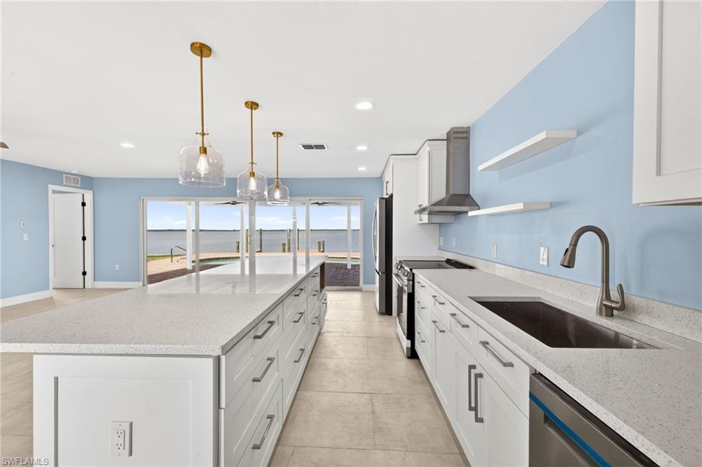 Kitchen with a large central island featuring white cabinetry and light-colored countertops