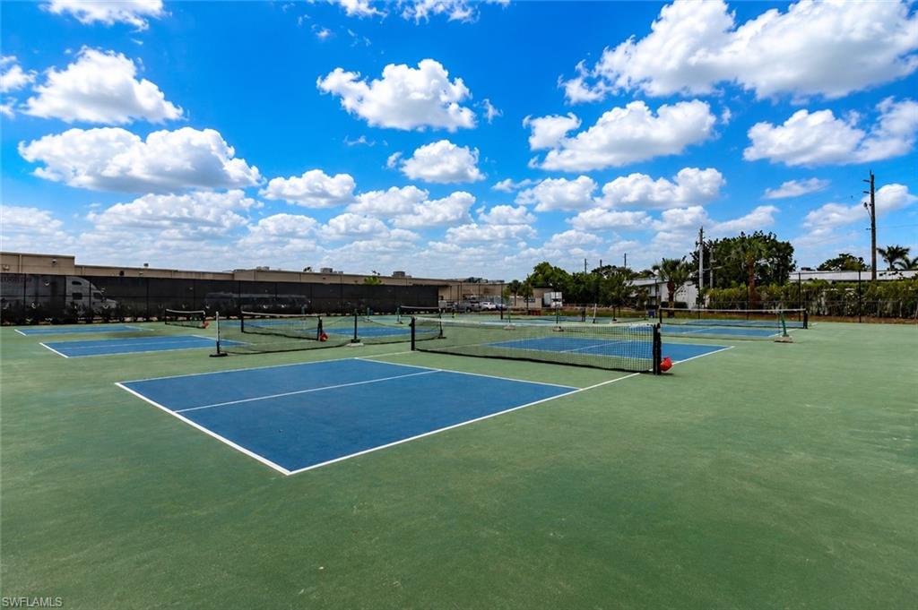 Community courts featuring multiple blue-surfaced playing areas with white line markings, surrounded by green court surfacing