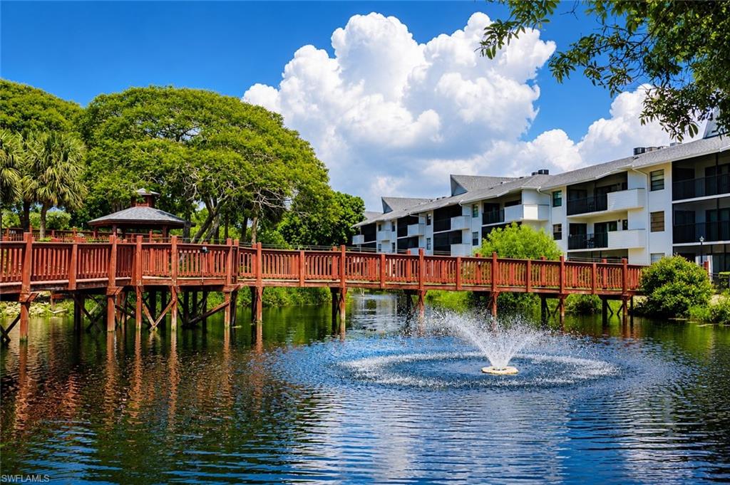 Water feature with a fountain, bordered by a wooden pedestrian bridge