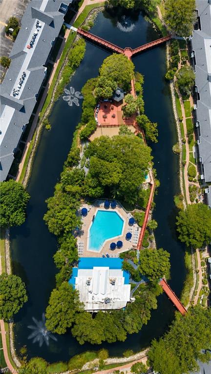 Central island with a large swimming pool, surrounding lounge seating, and an adjacent building featuring a blue roof