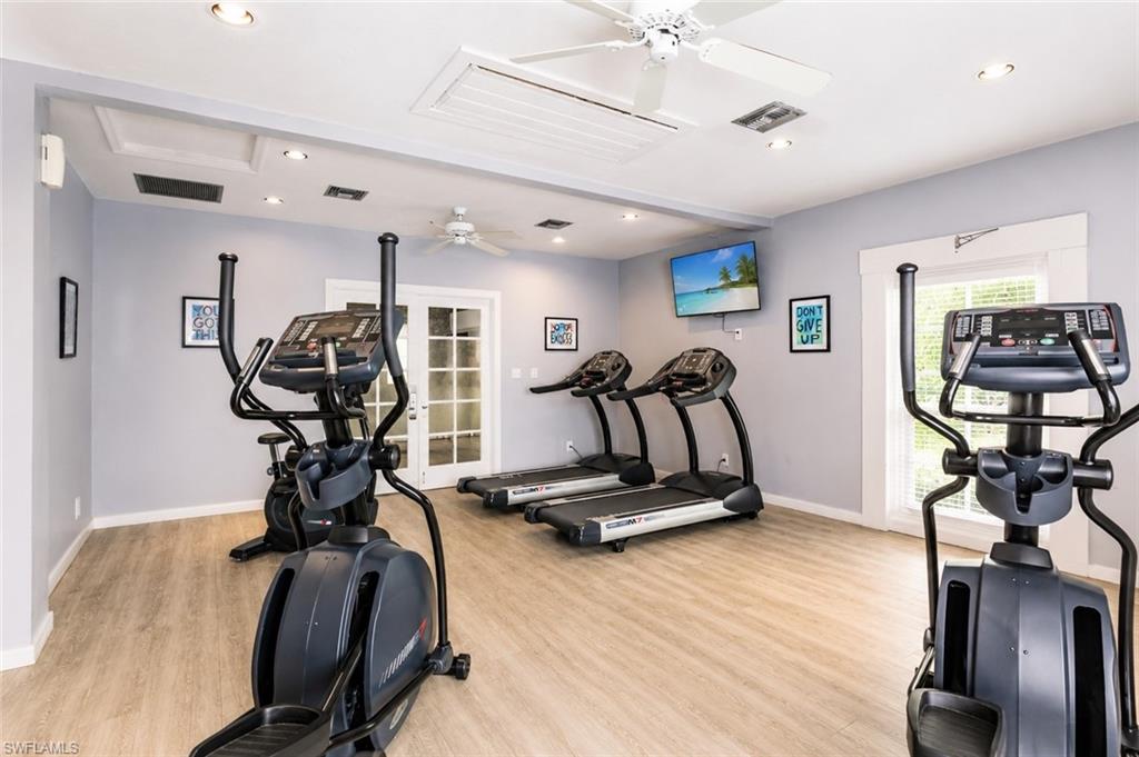 Dedicated fitness space featuring wood-finish flooring and light gray walls