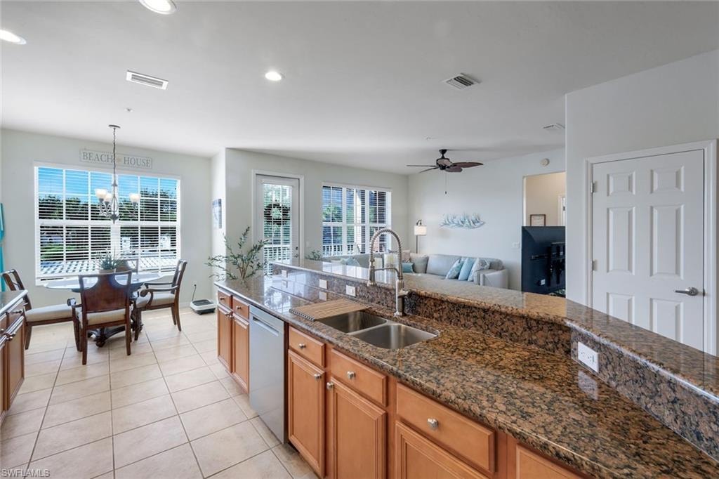 Kitchen with granite countertops, stainless steel sink, and wood cabinetry