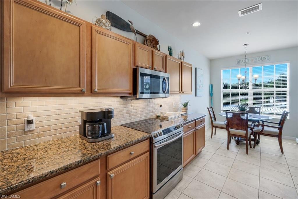 Kitchen featuring wood cabinetry, granite countertops, and a tiled backsplash
