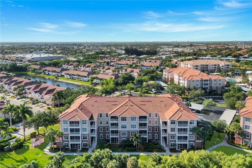 Multi-story residential building with terracotta tile roofing and multiple screened balconies