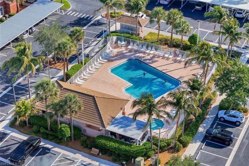 Community swimming pool with an integrated spa, surrounded by a spacious deck with lounge chairs