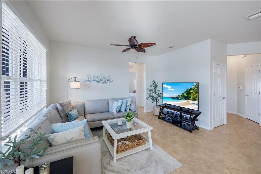 Bright living area featuring light-toned tile flooring and white walls