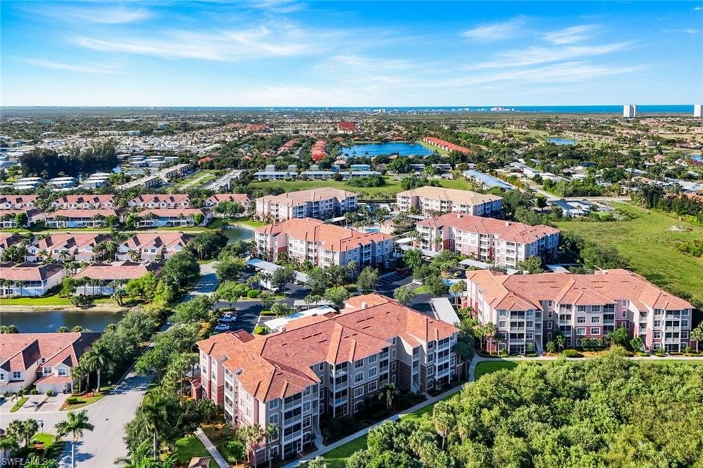 Aerial perspective showcasing a residential community with multiple multi-story buildings featuring red tile roofs