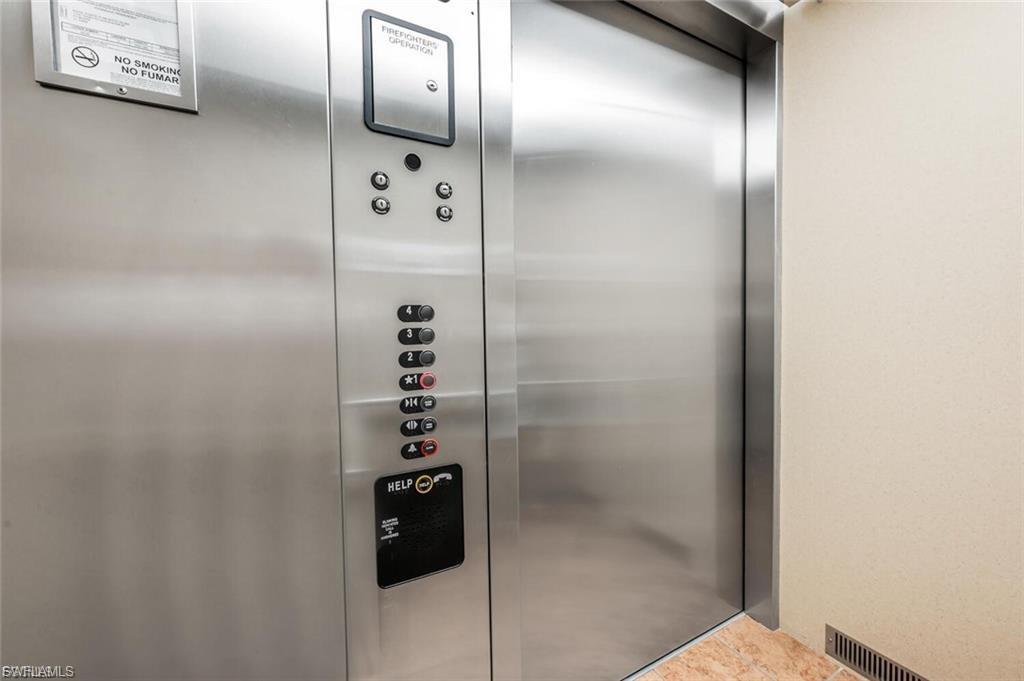 Stainless steel elevator doors featuring a control panel with multiple floor selections and a "HELP" button