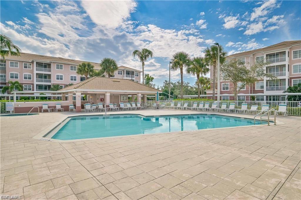 Rectangular swimming pool surrounded by a large paver deck