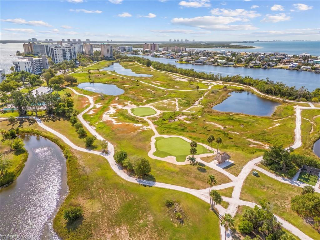 Expansive golf course and water features with multiple greens, sand traps, and walking paths
