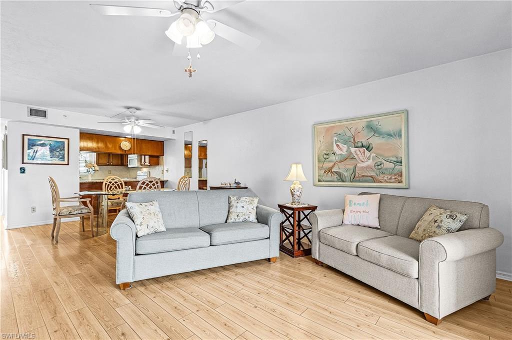 Spacious living area featuring wood-finish flooring and ceiling fans