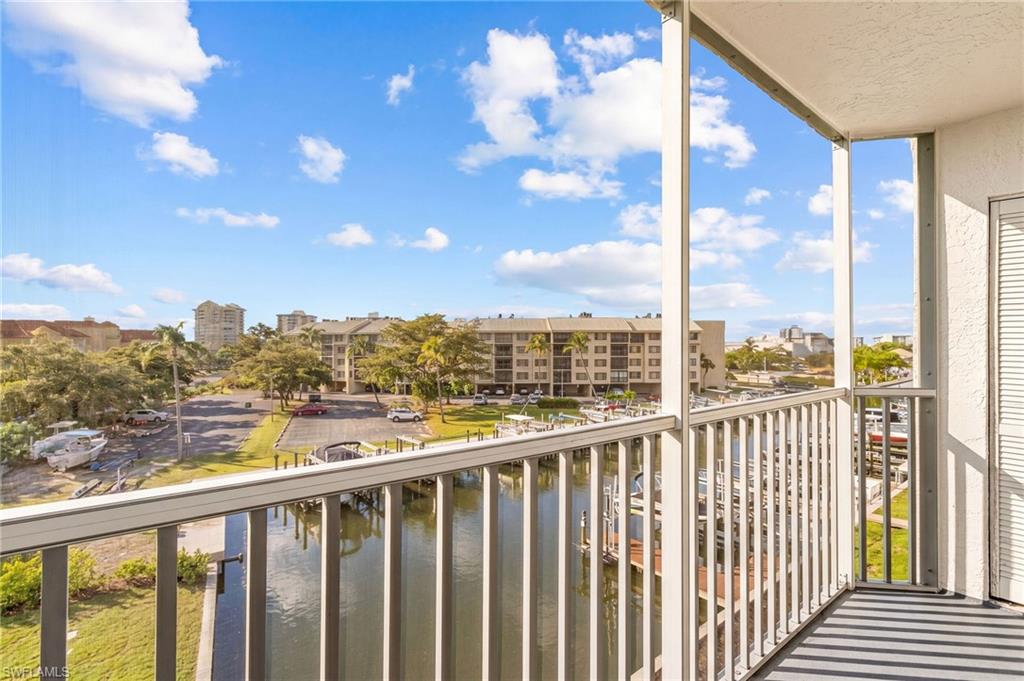 Screened balcony with water frontage featuring a boat dock with multiple slips