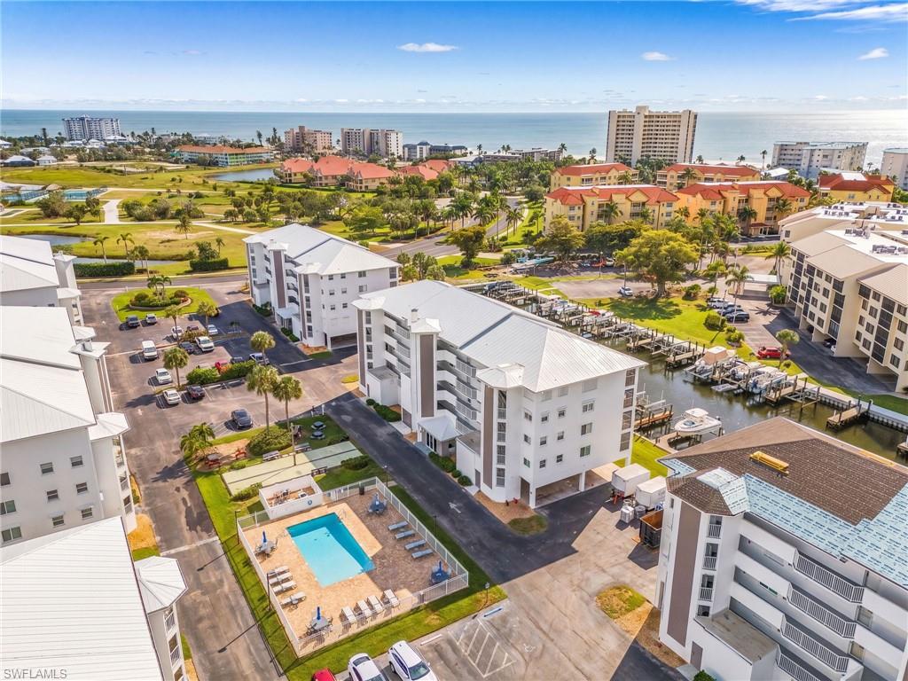 Waterfront condominium complex featuring a communal swimming pool, boat docks, and proximity to the ocean