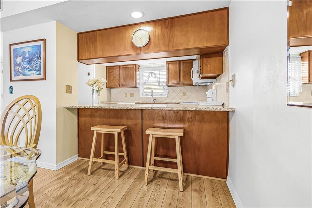 Kitchen pass-through with a stone-finish countertop and wood-finish cabinetry
