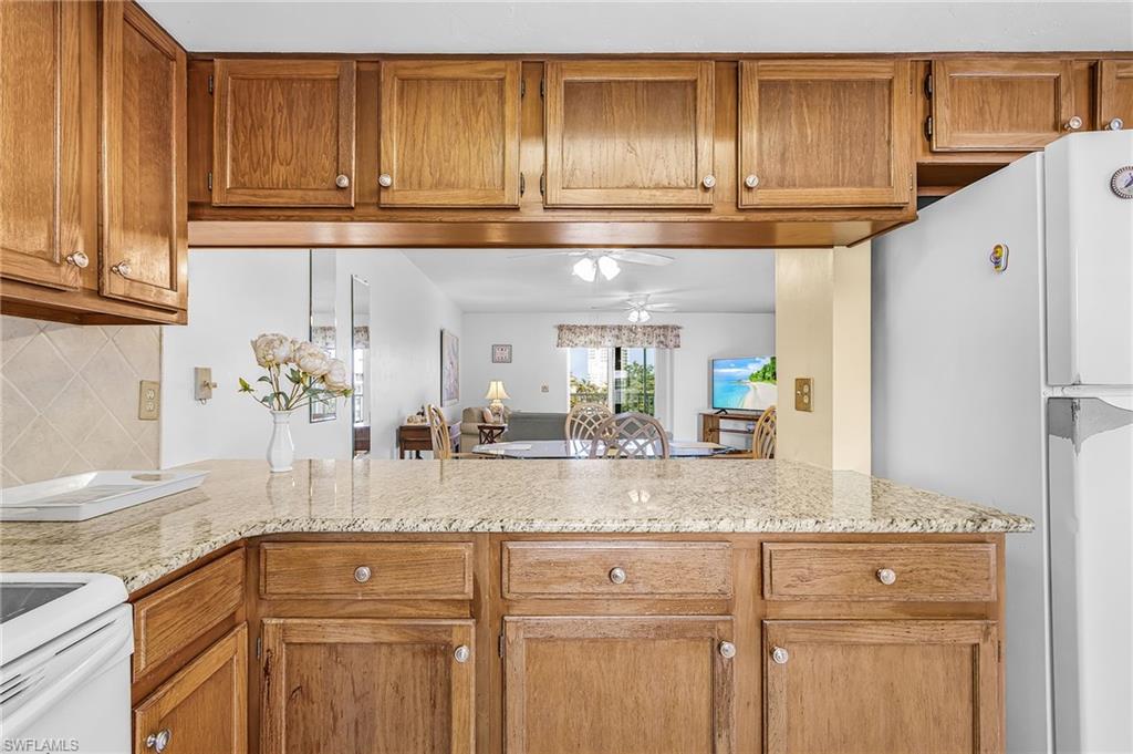 Kitchen featuring wood cabinetry, light-toned countertops, and a neutral tile backsplash