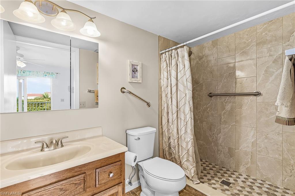 Bathroom featuring a wood-finish vanity with an integrated sink and a medicine cabinet with overhead illumination
