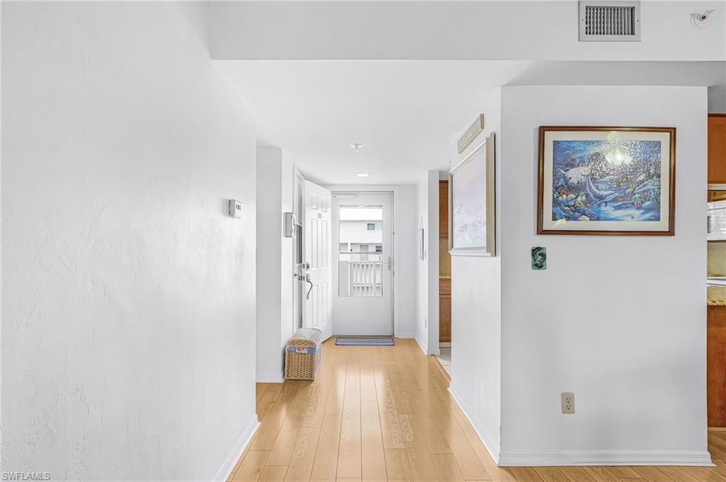 Entryway featuring light wood-finish flooring, white painted walls, and ceiling-mounted air conditioning vent
