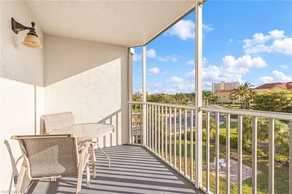 Outdoor balcony featuring textured stucco walls, a white metal railing, and an overhead light fixture