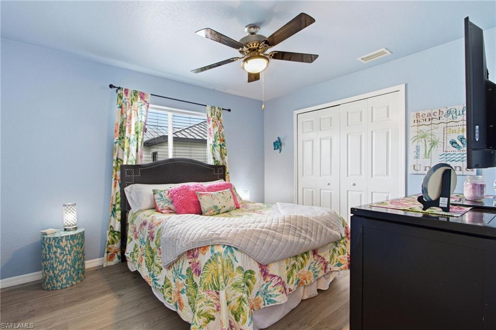 Room featuring wood-finish flooring and a ceiling fan with integrated lighting